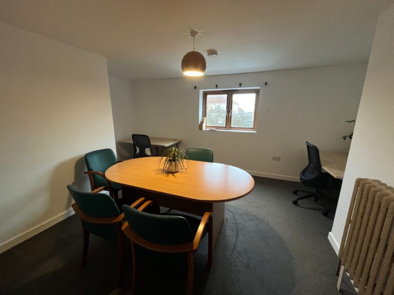 private office space with large meeting table and desks